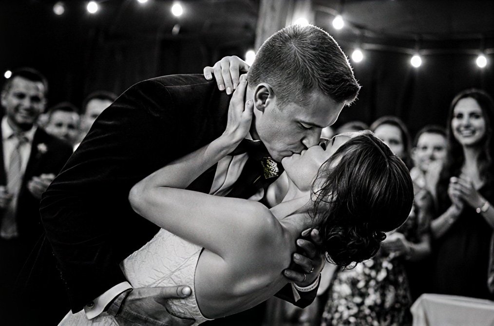 Newlyweds kissing on the dance floor in black and white